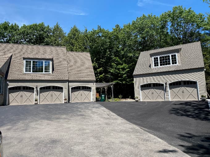 Three bay attached garage and a separate two bay garage, both with carriage doors and dormer windows