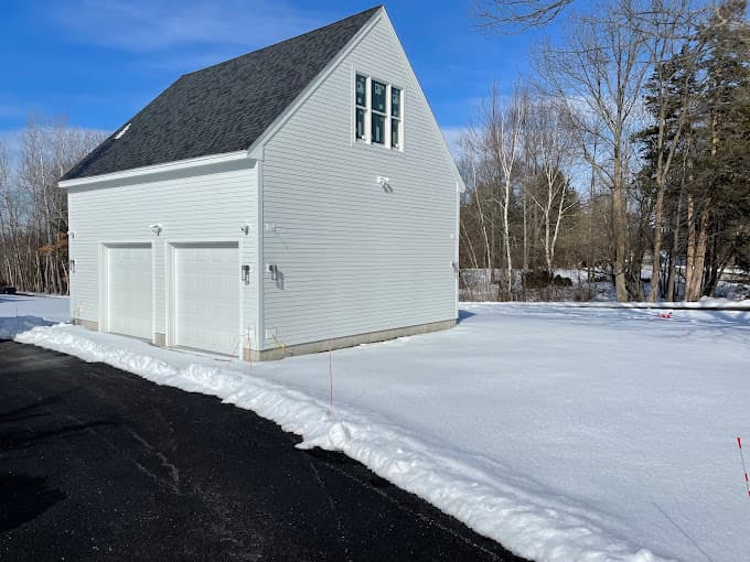 White two car detached garage with a loft window, finished over the winter in New Hampshire