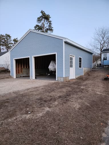 Blue two car detached garage nearing completion, with both bays open