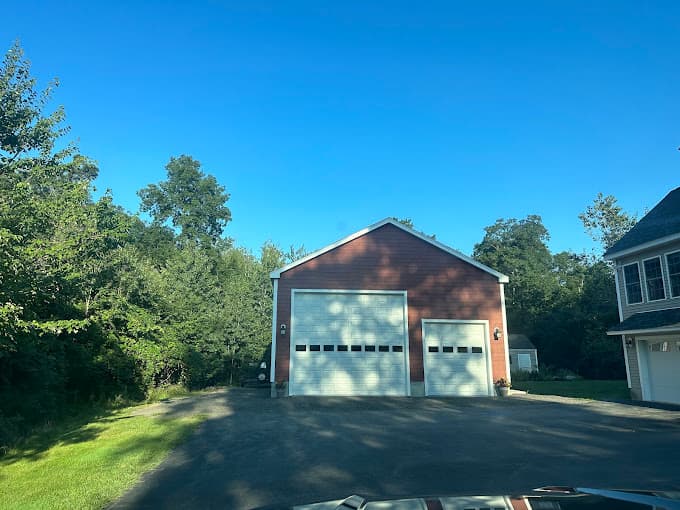 Barn red detached garage with one oversized bay and one standard bay